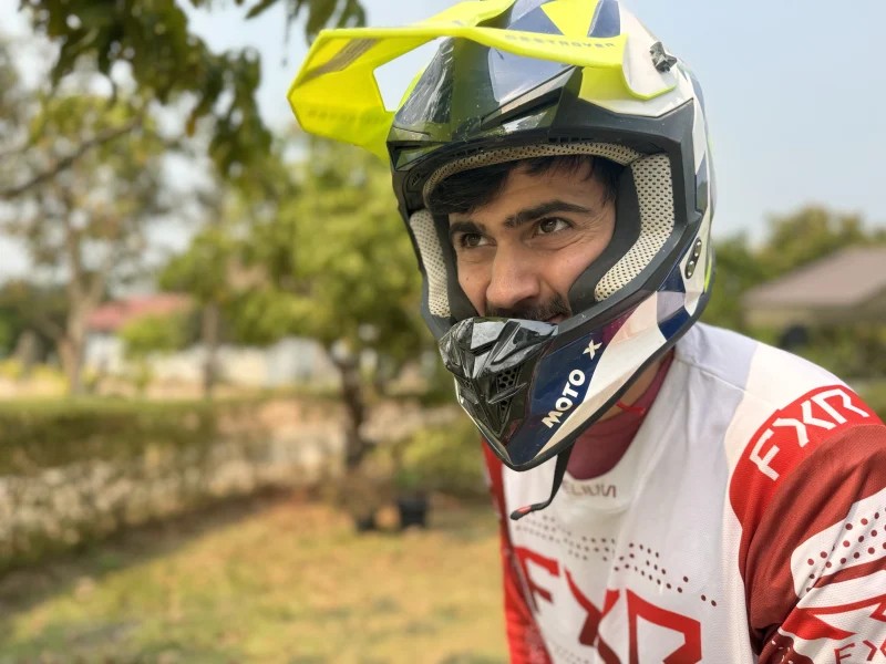 Rider wearing a snug-fitting off-road motorcycle helmet with cheek pads pressed against face