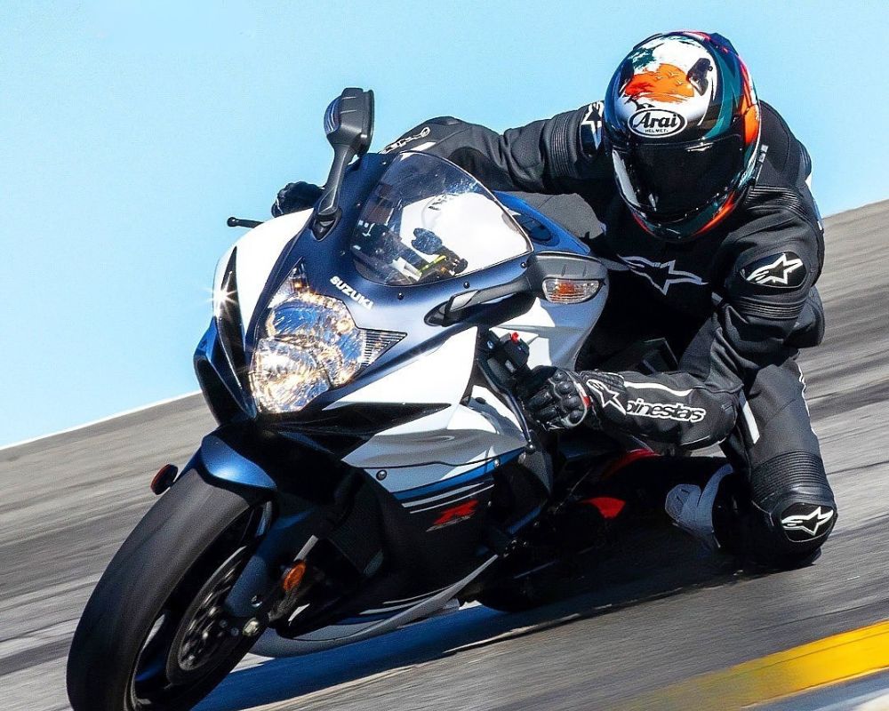 Rider wearing Arai Quantum-X helmet leaning aggressively into a turn on a sportbike