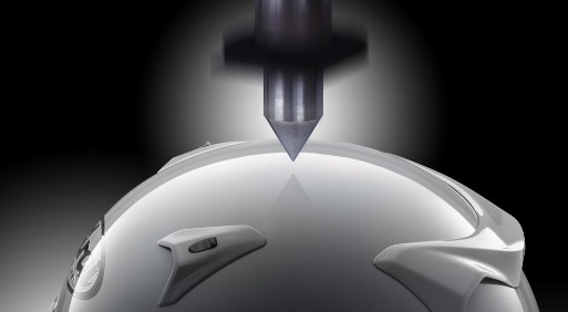 Arai helmet shell undergoing impact test to demonstrate Snell certification standards