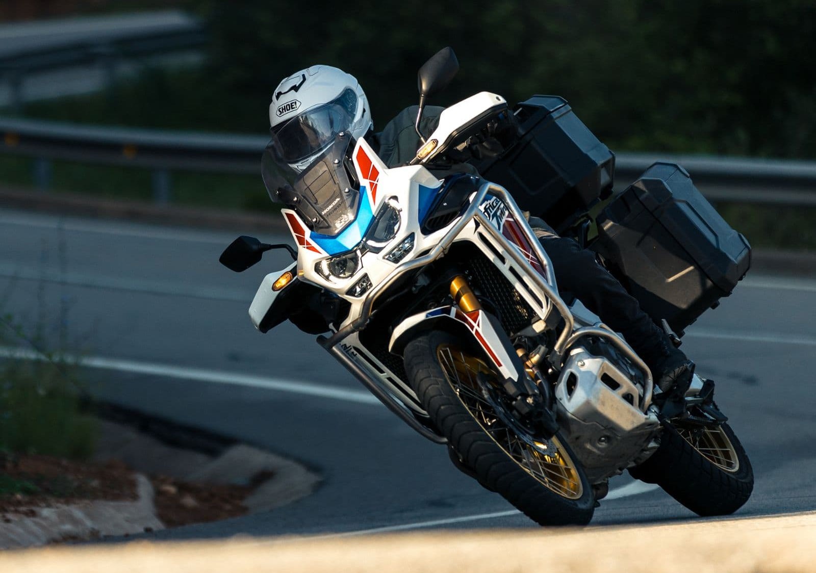 Shoei GT-Air 3 helmet on sport-touring rider leaning into a corner on a paved road