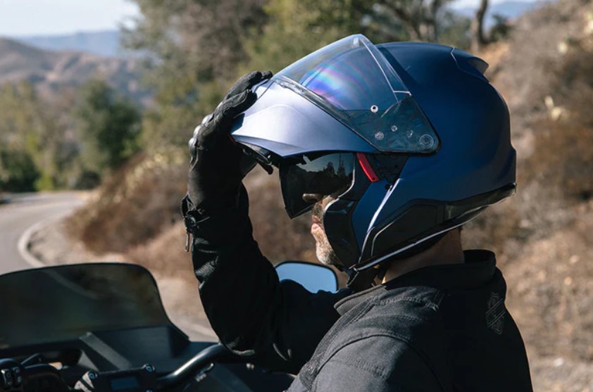 Rider wearing HJC RPHA 91 helmet with chin bar raised on a motorcycle