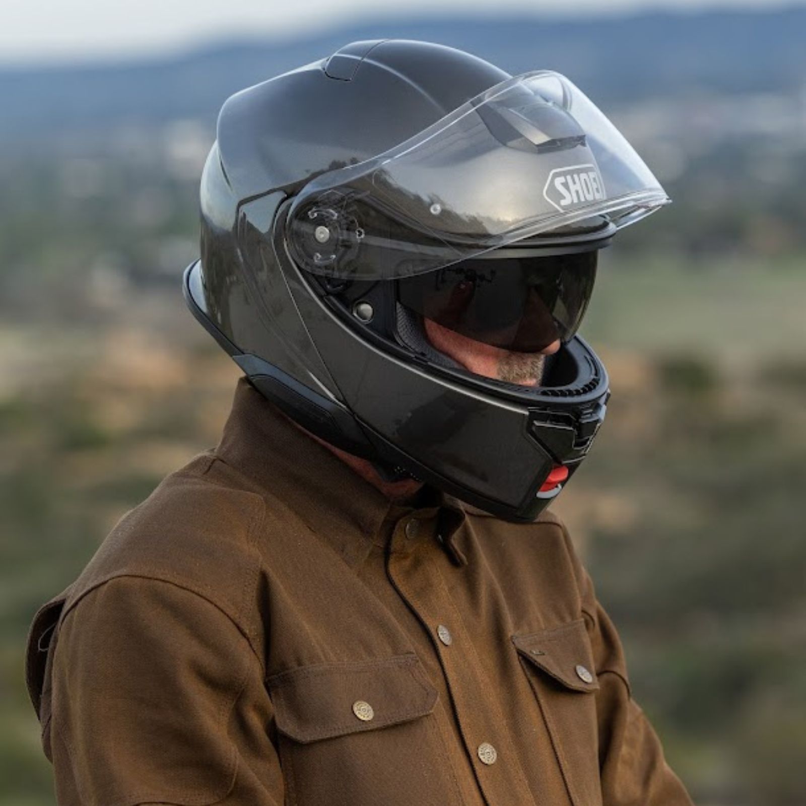 Shoei Neotec 3 helmet with visor raised showing internal sun shield and face coverage