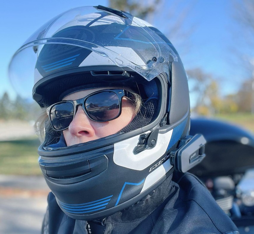 Rider wearing an Arai Regent-X helmet with an external Cardo communication unit mounted on the side