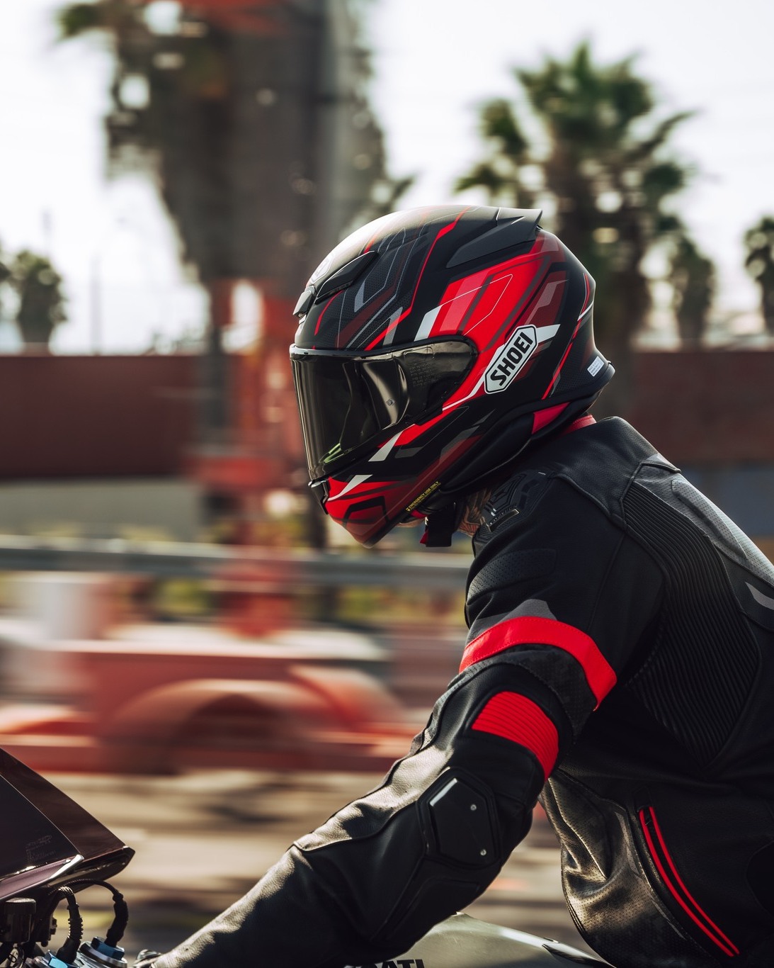 Rider wearing a Shoei RF-1400 helmet on a sportbike during highway riding