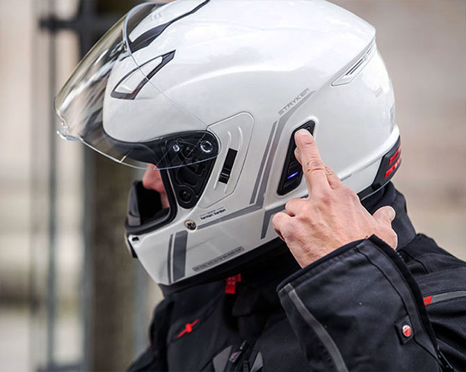 Rider using the integrated communication controls on a Sena Stryker helmet